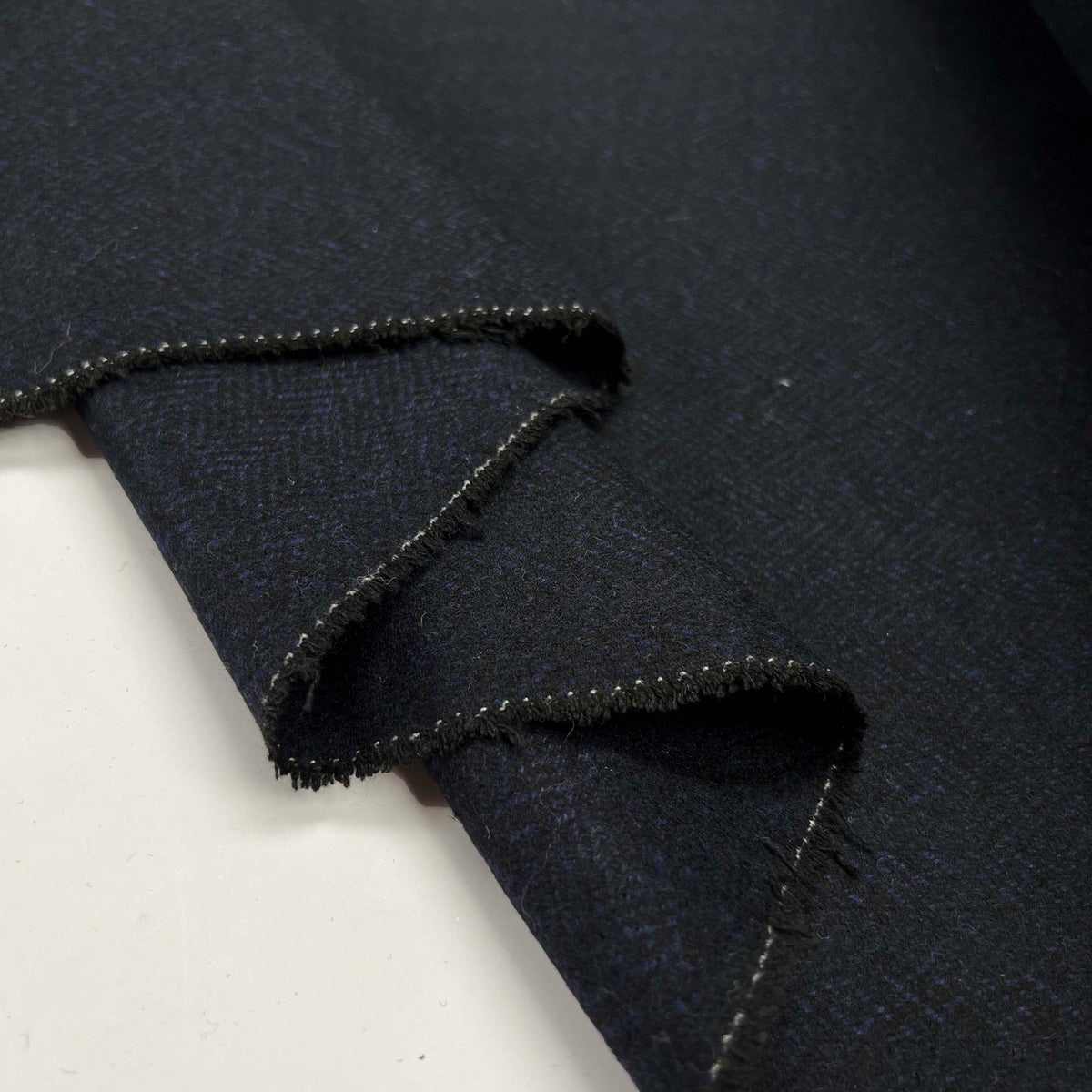 Moody Blues Polyester Wool Mix Blue Black Herringbone Suiting Fabric Fold