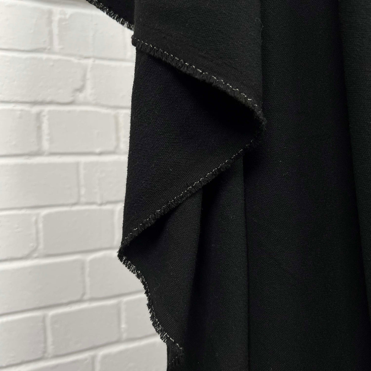 Moving Well Polyester Wool Elastane Black Midweight Portuguese Suiting Fabric Hang