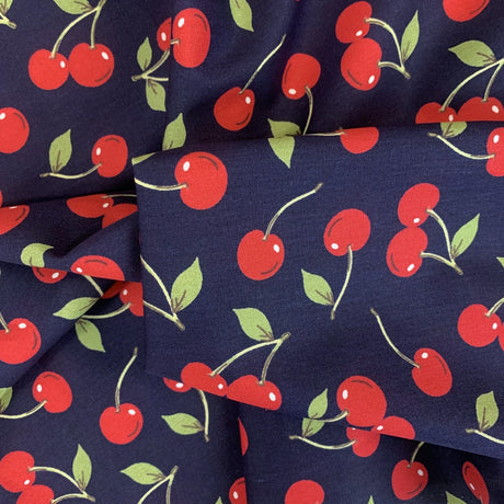 Poplin Print Cherries Navy Cotton With Red Cherries On And Green Leaves Fold