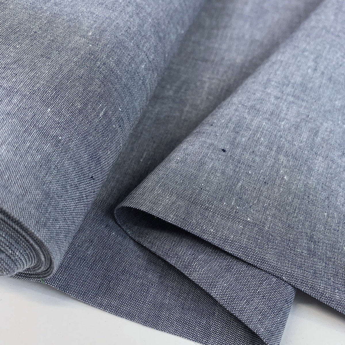 https://www.croftmill.co.uk/images/pictures/2-2021/08-august-2021-2/finest-chambray-navy-cotton-fabric-fold.jpg?v=71fc1295